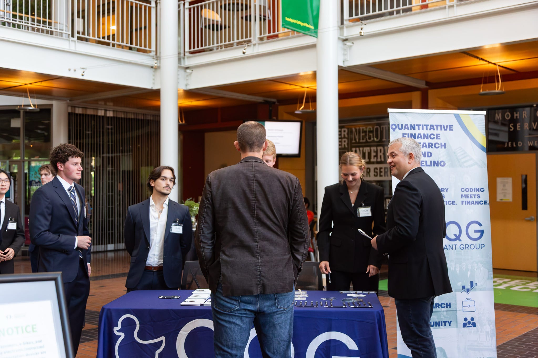 A member at the OQG table beside the Quantitative Finance Research and Modeling banner